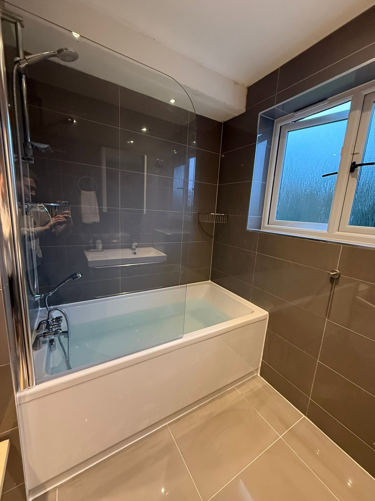 Finished grey tiled bathroom with shower screen